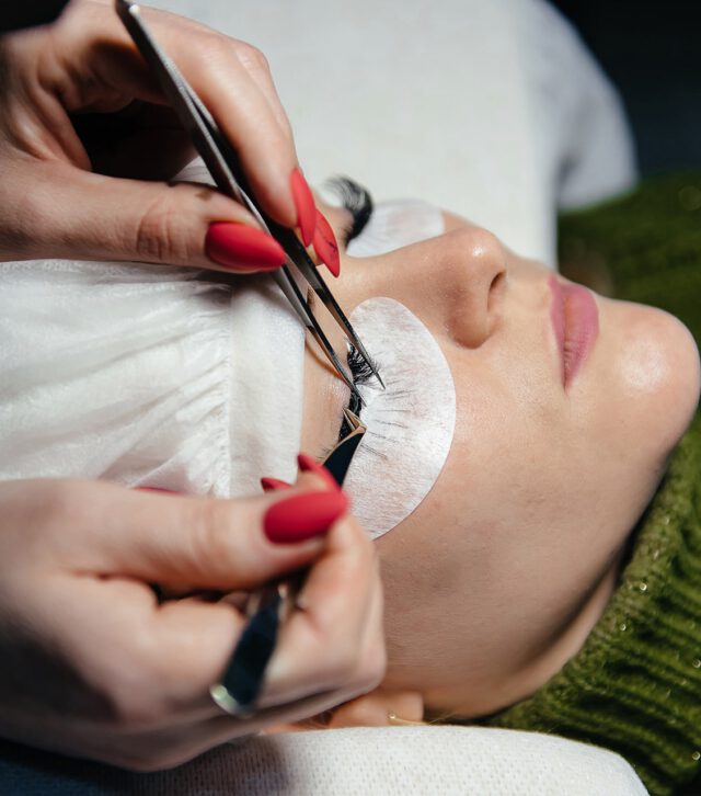 eyelash-extension-process-closeup-portrait-young-girl-woman-with-long-thick-eyelashes-eyes-closed-hand-cosmetologist-adding-more-eyelashes-her